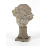 A stone carving of a child's head, wearing a tasseled cap, possibly 18th century,
