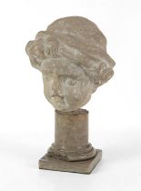 A stone carving of a child's head, wearing a tasseled cap, possibly 18th century,