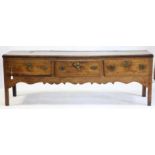 18th/19th century oak dresser base, with three drawers over shaped apron, on reduced square legs,