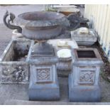 Pair of cast iron shallow campana shape garden urns, with scrolling twin handles and square bases,