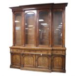 Mid Victorian mahogany breakfront bookcase, the cavetto moulded cornice over four glazed doors with