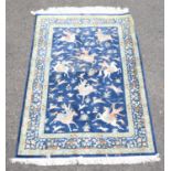 Persian silk hunting scene rug, depicting eight horseman on a blue field, within a floral and
