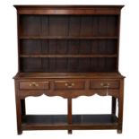 Early 19th century oak dresser and rack, with moulded cornice over two shelves and a base with