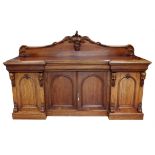 Mid Victorian mahogany inverted breakfront sideboard, the raised back carved with grapes and