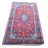 Persian Kashan rug, central floral medallion and scrolling floral design on a red ground within