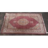 Tabriz rug, the ivory medallion and spandrels on a red field with allover design, 209 x 127 cm