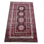 Turkoman rug, with four medallions on a black ground within floral borders, 205 x 115cm