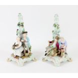Pair of Dresden porcelain candle holders modelled with figures on scroll feet, 27.5 cm high