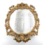 19th century carved giltwood wall mirror, the oval plate within a pierced scroll and floral carved