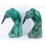 Pair of green and blue glazed stoneware figures of storks, standing in rushes, 68 cm high