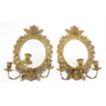 Pair of early 20th century three branch gilt metal wall sconces with oval mirrored backs, 45cm high,