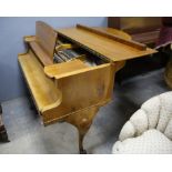 Walnut cased baby grand piano by Niendorf Berlin, with lyre shape pedal support and shell carved