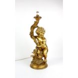 Large gilt plaster table lamp, in the form of a cherub holding a torch, 67 cm high, with shade