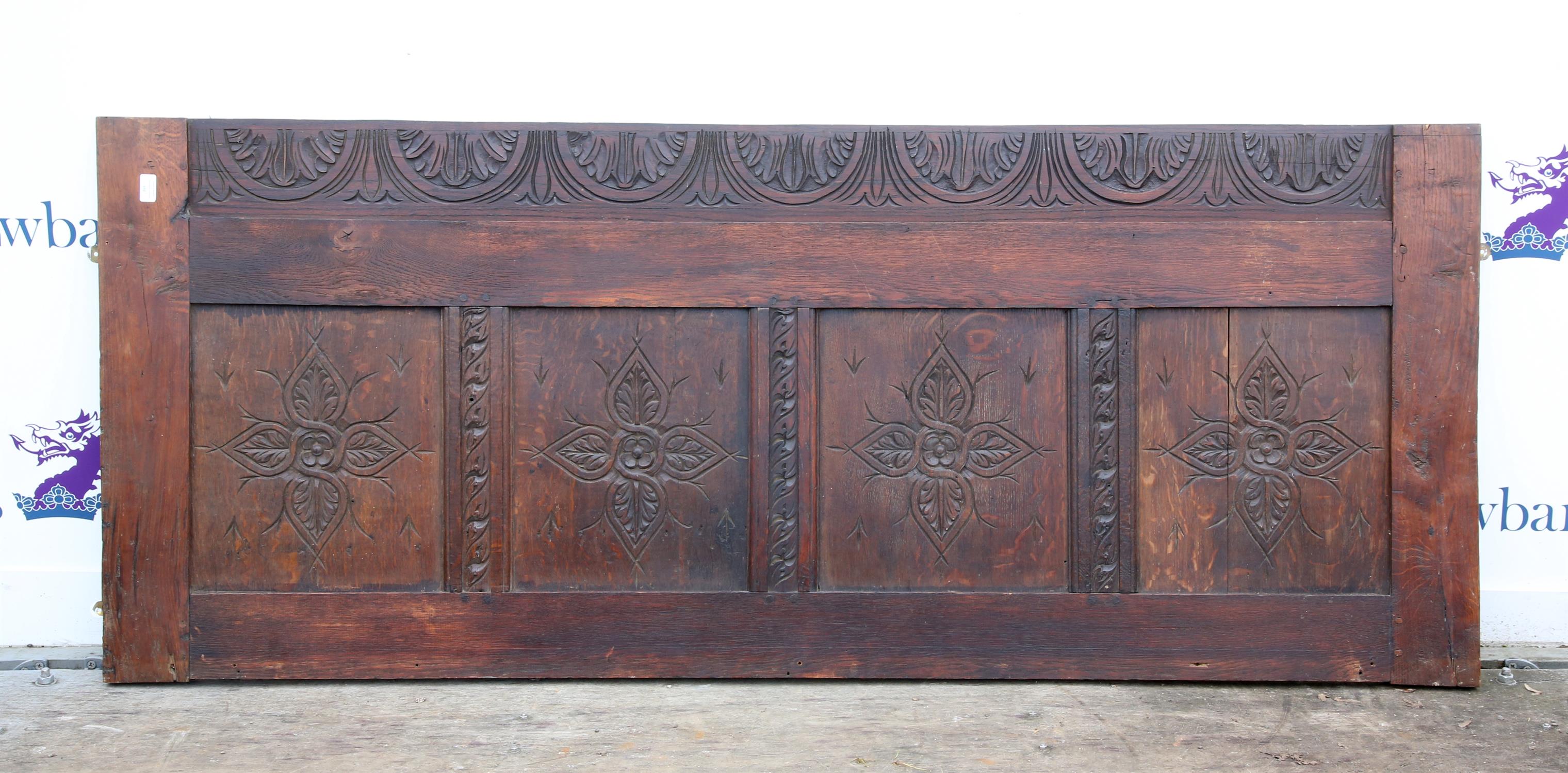 Oak four panelled board, the panels carved with a quatrefoil, over a later lunette carved base,