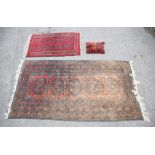 An Afghan rug, with five medallions on a faded red field within a multiple border, 247 x 130 cm,