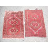 Pair of Afghan prayer rugs, with twin medallions on a red field within a floral border, 113 x 75 cm