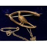 A 9CT YELLOW GOLD WISHBONE BROOCH SET WITH PHEASANT SAFETY CHAIN ATTACHED 1.9G GROSS