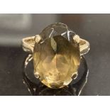 9CT YELLOW GOLD SMOKEY QUARTZ RING COMPRISING OF A SINGLE LARGE OVAL STONE IN A FOUR CLAW SETTING