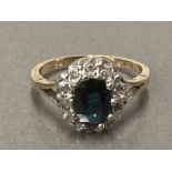 A 9CT YELLOW GOLD OVAL SAPPHIRE AND DIAMOND CLUSTER RING SIZE SIZE K 1/2 2.7G GROSS