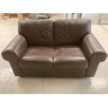 A MODERN BROWN LEATHERETTE TWO SEATER SOFA