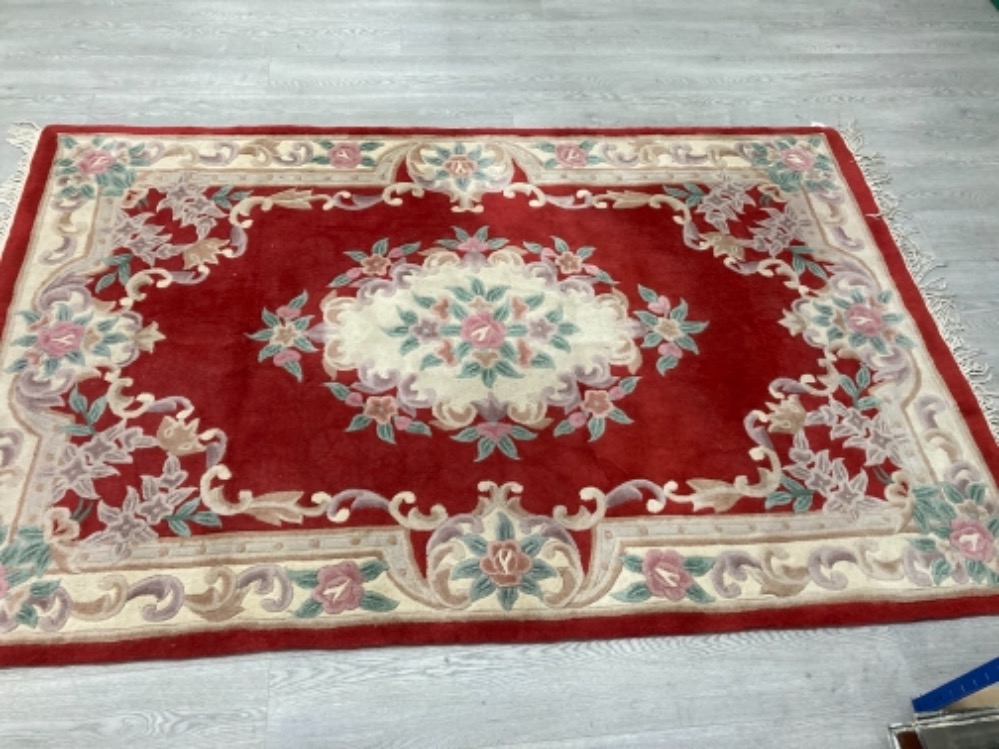 A MODERN CHINESE RUG FLORAL DECORATION ON RED GROUND 240 X 155CM