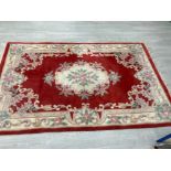 A MODERN CHINESE RUG FLORAL DECORATION ON RED GROUND 240 X 155CM