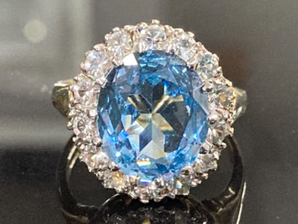 9CT YELLOW GOLD BLUE TOPAZ AND CUBIC ZIRCONIA CLUSTER RING COMPRISING OF A SINGLE BLUE TOPAZ STONE