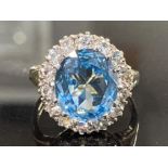9CT YELLOW GOLD BLUE TOPAZ AND CUBIC ZIRCONIA CLUSTER RING COMPRISING OF A SINGLE BLUE TOPAZ STONE