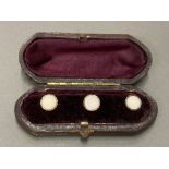 A SET OF THREE GOLD PLATED DRESS STUDS CASED