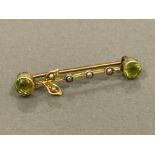 9CT GOLD BAR BROOCH SET WITH 2 ROUND PERIDOTS AND 5 PEARLS 1.4G