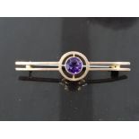 9CT YELLOW GOLD ORNATE BROOCH SET WITH A SINGLE ROUND CUT AMETHYST STONE