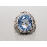 9CT YELLOW GOLD LADIES BLUE TOPAZ AND CZ CLUSTER RING FEATURING AN OVAL SHAPED BLUE TOPAZ SET IN THE