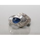 9CT WHITE GOLD LADIES BLUE STONE AND DIAMOND ORNATE RING FEATURING A BLUE PEAR SHAPED RUB OVER STONE