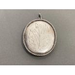 SILVER LADIES OVAL SHAPED LOCKET WITH ROPE EDGE AND FLOWER AND LEAF DESIGN ON THE FRONT 14.2G