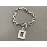 SILVER BRACELET FEATURING OVAL LINKS WITH SQUARE SHAPED MOTHER OF PEARL CHARM COMPLETE WITH T BAR