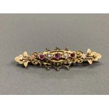 15CT YELLOW GOLD FANCY ORNATE BROOCH SET WITH THREE ROUND CUT RUBYS AND TWO PEARLS 3.6G
