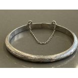 SMALL HOLLOW SILVER BANGLE WITH ORNATE PATTERN COMPLETE WITH SAFETY CHAIN 5.6G