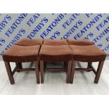 A SET OF 6 UPHOLSTERED HARDWOOD STOOLS WITH RECTANGULAR DISHED SEATS ON SQUARE COLUMN LEGS JOINED BY