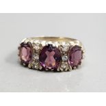 SILVER GOLD PLATED THREE STONE RING COMPRISING OF THREE OVAL PURPLE STONES SET WITH THREE ROUND