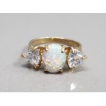 9CT YELLOW GOLD OPAL AND CZ 3 STONE RING FEATURING A OVAL SHAPED OPAL SET IN THE CENTRE SET WITH A