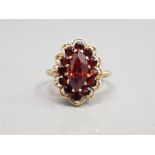 9CT YELLOW GOLD GARNET AND CLUSTER RING FEATURING OF A CLUSTER GARNET STONE SET IN ORNATE EDGE