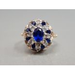 9CT YELLOW GOLD SAPPHIRE AND CUBIC ZIRCONIA CLUSTER RING FEATURING BLUE AND A WHITE STONES SET IN AN