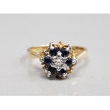 18CT YELLOW GOLD SAPPHIRE AND DIAMOND CLUSTER RING FEATURING A BRILLIANT ROUND CUT DIAMOND SET IN