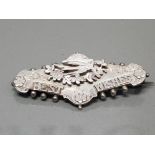 SILVER ORNATE BROOCH SET WITH FLOWER DESIGN WITH A BIRD SET AT THE TOP "BEST WISHES" AT THE BOTTOM
