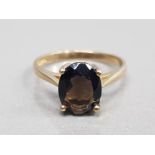 9CT YELLOW GOLD OVAL SMOKEY QUARTZ RING COMPRISING OF A OVAL CUT STONE IN A FOUR CLAW SETTING SIZE J