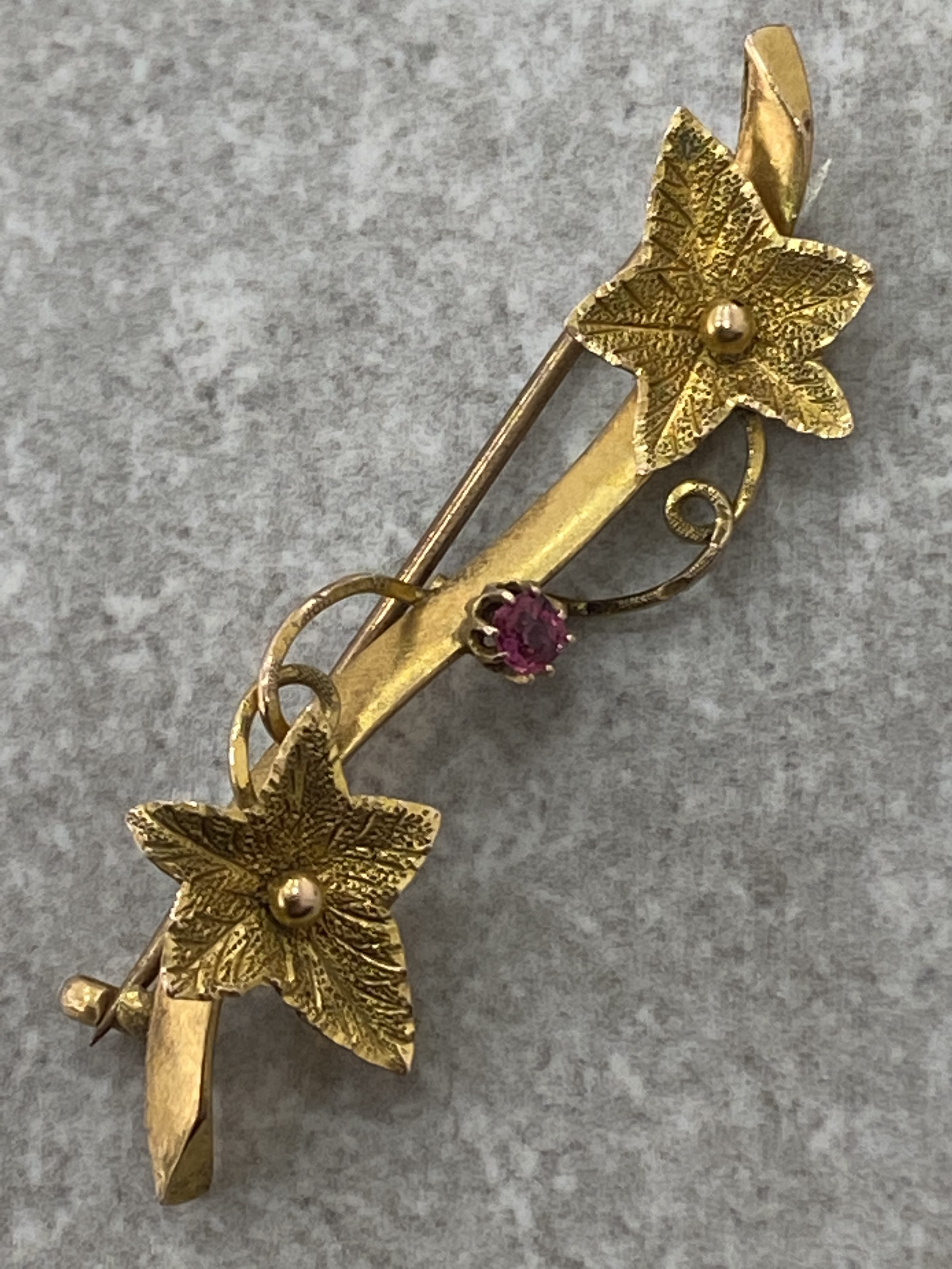 LADIES ANTIQUE 9CT GOLD BROOCH SET WITH RUBY CENTRE STONE AND LEAF DESIGN