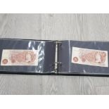 A COVER ALBUM CONTAINING 14 TEN SHILLING NOTES AND ONE POUND NOTE