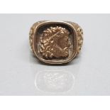 GENTS 9CT YELLOW GOLD RING WITH CLASSICAL HEAD TO THE FACE WITH OLYMPIC STYLE DECORATION ON BARK