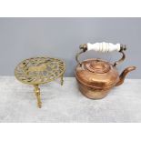 ANTIQUE BRASS AND COPPER KETTLE WITH PORCELAIN HANDLE PLUS A BRASS TRIVET STAND WITH HORSE DESIGN