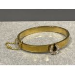 Gold (high carat) Victorian plain bangle with central 9 diamond set horseshoe motif and safety chain